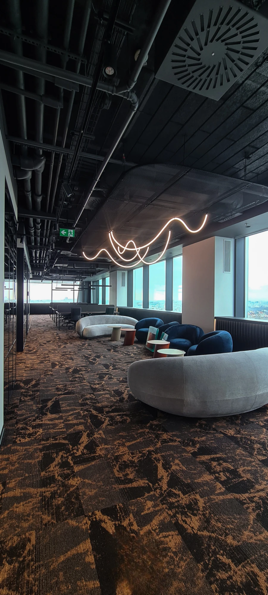 The ONE Office, zonă de lounge cu canapele și corp de iluminat sculptural